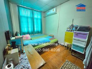 Bedroom with bed, air conditioning, colorful storage unit, and window with green curtains