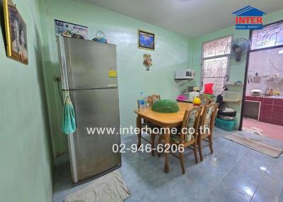 Dining area in a kitchen with a refrigerator, dining table, and microwave