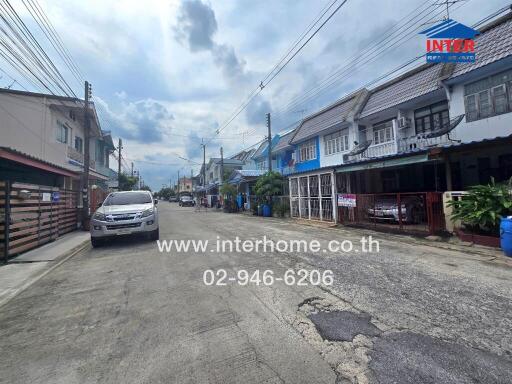 View of a residential street with houses and parked cars