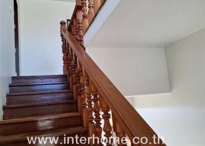 Indoor staircase with wooden railings leading to the upper level