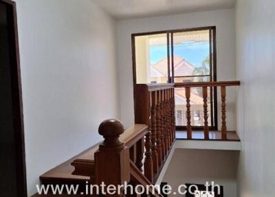 Interior staircase area with wooden railings and natural light