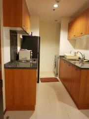 Modern kitchen with wooden cabinets, black countertops, and appliances