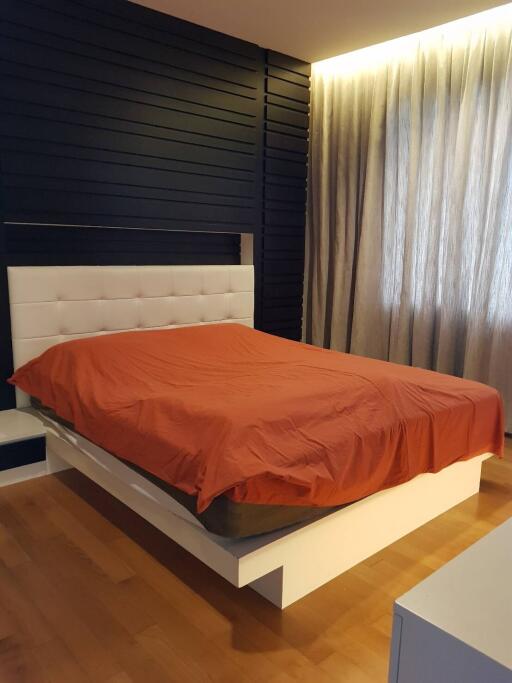 Modern bedroom with a double bed and red bedspread