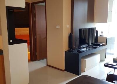 modern living room with TV, cabinets, and a view into the hallway