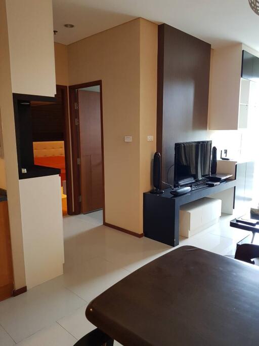 modern living room with TV, cabinets, and a view into the hallway