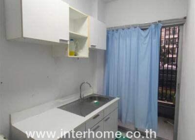 simple kitchen with white cabinets and a blue curtain