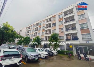 Exterior view of a multi-story residential building with parking space