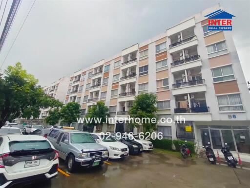 Exterior view of a multi-story residential building with parking space