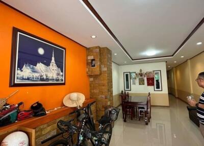 Well-lit hallway with bicycles and a dining area