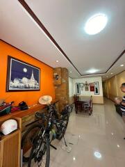 Well-lit hallway with bicycles and a dining area