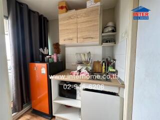 Compact kitchen with wooden cabinets and red refrigerator