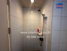 Shower area with white tile walls