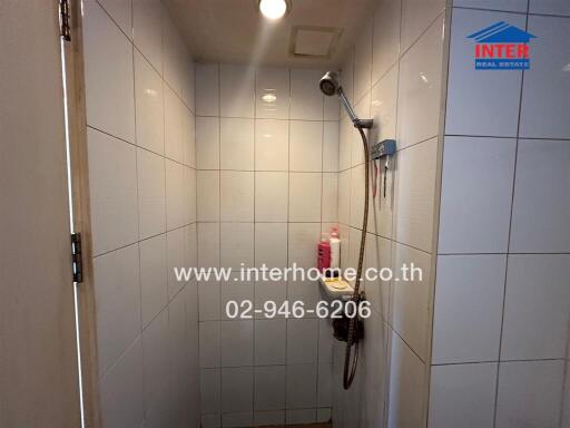 Shower area with white tile walls