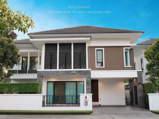 Modern two-story house with large windows and trees