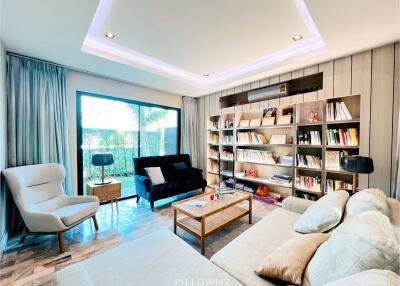 Modern living room with large window, shelves, and comfortable seating