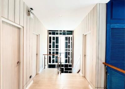 Modern hallway with light wood paneling and contemporary decor