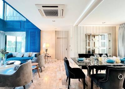 Modern open-concept living and dining area with blue accent wall