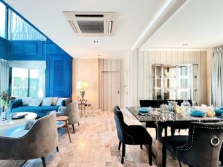 Modern open-concept living and dining area with blue accent wall