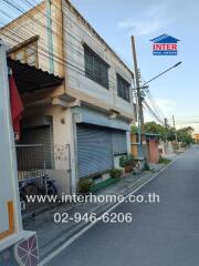 Street view of a commercial building with shutter doors