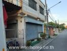 Street view of a commercial building with shutter doors