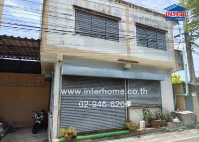 Two-story commercial building with shuttered storefront