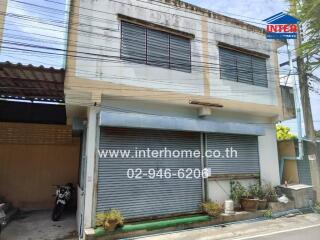 Two-story commercial building with shuttered storefront