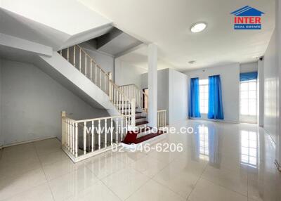 Bright living room with staircase and large windows