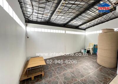 Covered outdoor space with tiled flooring and storage