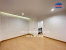 Empty bedroom with wooden floor and white walls.