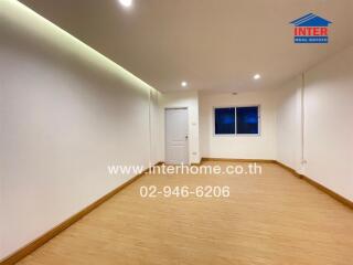 Spacious unfurnished room with white walls and wooden floor