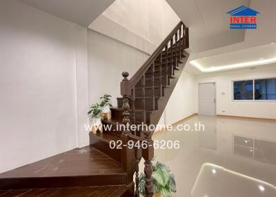 Staircase leading to upper floor with plants and glossy floor