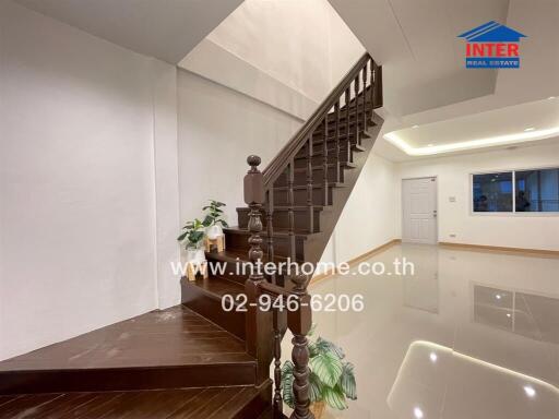 Staircase leading to upper floor with plants and glossy floor