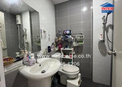 A compact bathroom with essential amenities and a shower area.