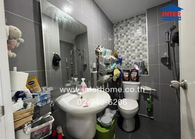 Bathroom with sink, mirror, toilet, and storage racks