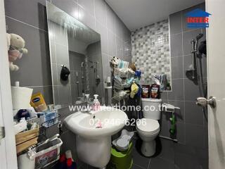 Bathroom with sink, mirror, toilet, and storage racks