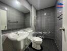 Modern bathroom with gray tiled walls, a shower, toilet, and sink