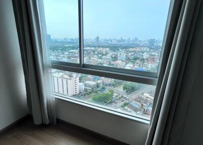 Bedroom with large window and city view