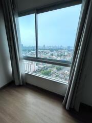 Bedroom with large window and city view