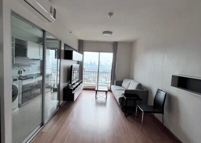 Modern living room with wood flooring and a balcony view.