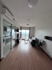 Modern living room with wood flooring and a balcony view.