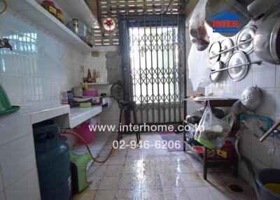 Compact kitchen space with various kitchen appliances and storage shelves