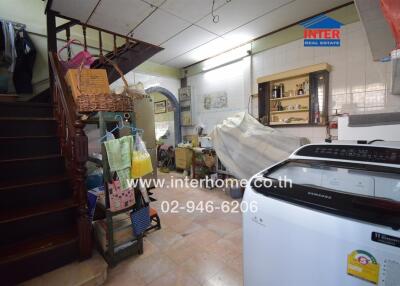 Laundry area with stairs and various household items