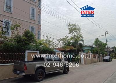 Street view of a residential area with houses and a pickup truck