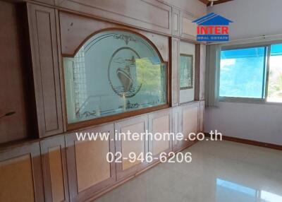 Living room with large window and wooden wall paneling