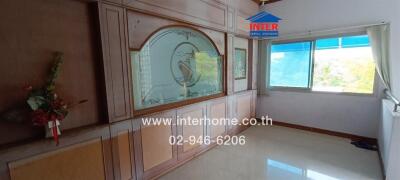 Living room with large window and wooden wall paneling