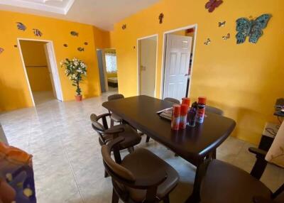 Bright dining room with yellow walls, butterfly decorations, and a dark wooden dining table with chairs