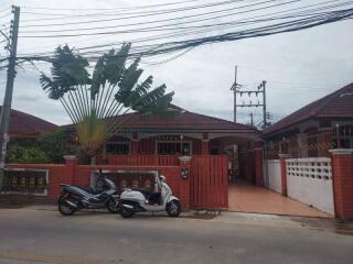 Front view of a residential property with a red fence and gate