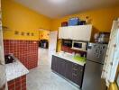 Modern kitchen with yellow walls and red tile backsplash