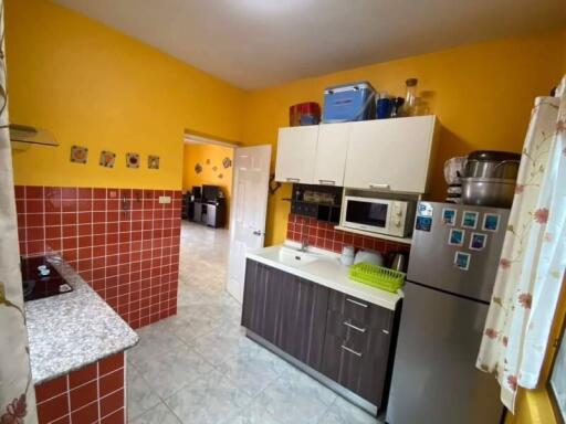 Modern kitchen with yellow walls and red tile backsplash