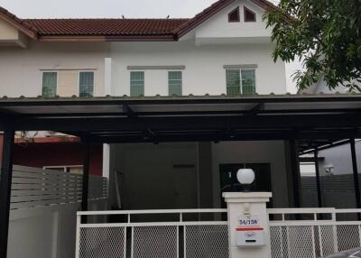 Front of the house with gate and carport